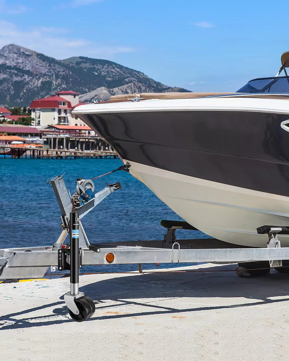 Boat on a trailer wheel jack at a dock with mountains